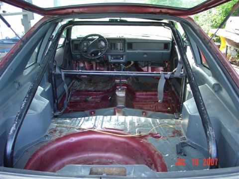 1984 Ford Mustang - Interior view of a 1984 Ford Mustang, showing a roll cage and stripped-down interior.