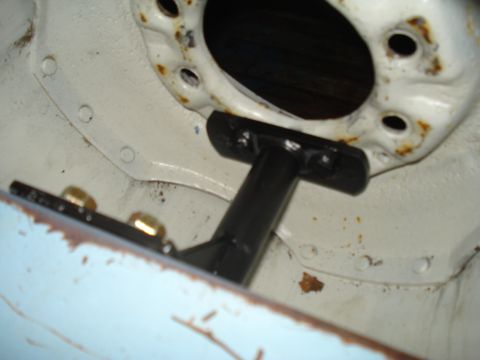 1967 Ford F-250 - A close-up view of a vehicle's frame shows a black bracket bolted to the chassis, with signs of rust on the metal.