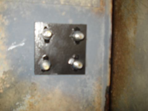 1967 Ford F-250 - A metal plate with four bolts is attached to a rusty, weathered surface.