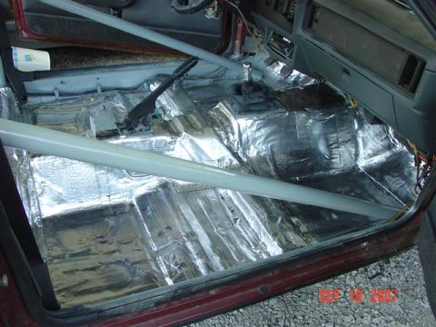 1984 Ford Mustang - The interior of a 1984 Ford Mustang shows sound deadening material applied to the floor and a roll cage installed.