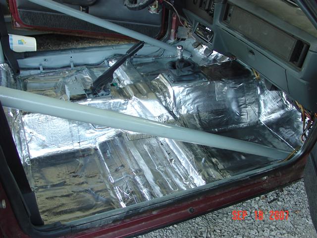 Interior of a 1984 Ford Mustang with sound deadening and roll cage
