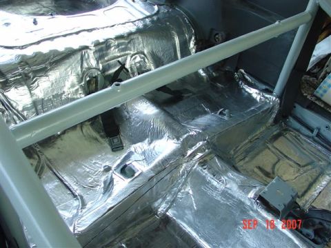 1984 Ford Mustang - Car interior undergoing sound deadening installation with a roll bar visible.