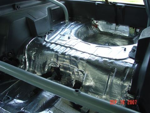1984 Ford Mustang - The interior of a 1984 Ford Mustang shows extensive sound deadening material applied to the floor and rear transmission tunnel.