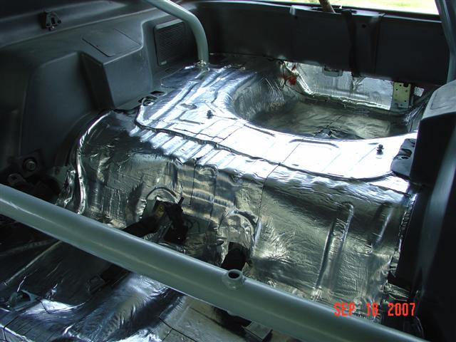1984 Ford Mustang interior with sound deadening material covering the floor and transmission tunnel