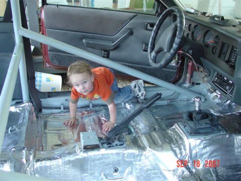 1984 Ford Mustang - A young child explores the interior of a car that is undergoing modifications, including sound dampening and a roll cage.