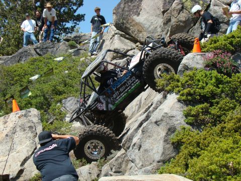 1989 Ford Bronco - A heavily modified off-road buggy navigates a steep, rocky incline with spectators watching from above. The buggy features a roll cage, lar…
