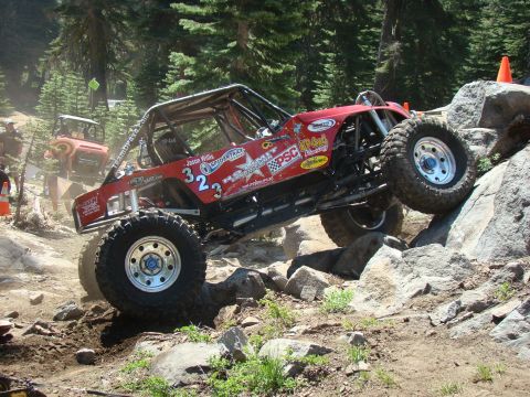 1989 Ford Bronco - Custom off-road buggy tackles a challenging rock climb on a wooded trail.