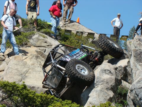 1989 Ford Bronco - A custom-built off-road buggy navigates a challenging rocky incline with spectators observing the action.