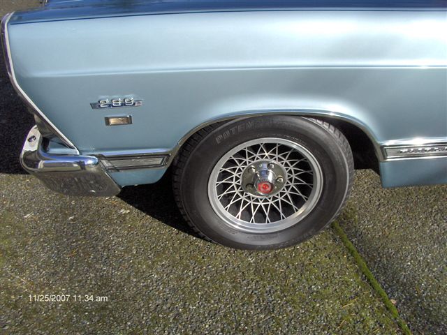 Light blue classic Ford fender and wire-spoke wheel with red center cap