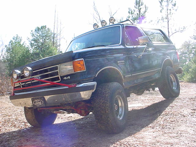 1989 Ford Bronco, 3/4 front view, dark blue with off-road lights