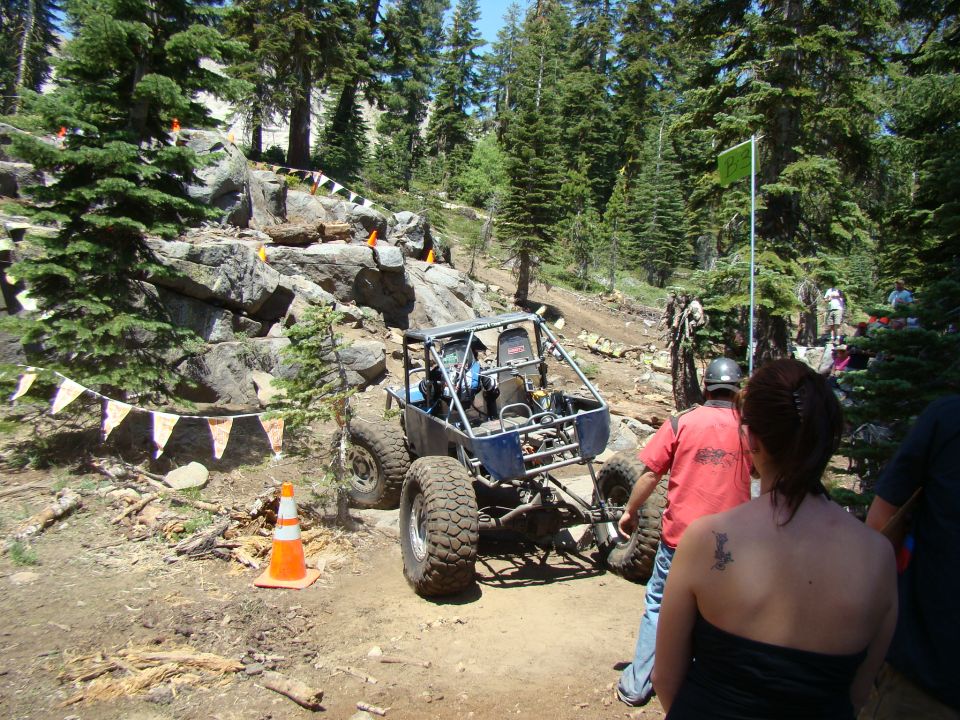 Blue off-road buggy with roll cage on rocky terrain