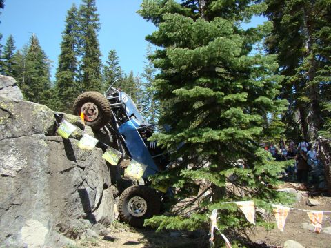1989 Ford Bronco - An off-road vehicle navigates a rocky incline with spectators watching.