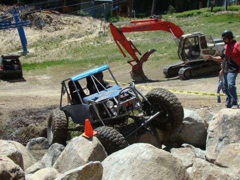 1989 Ford Bronco - A custom-built buggy maneuvers through a rocky obstacle course, with construction equipment visible in the background.
