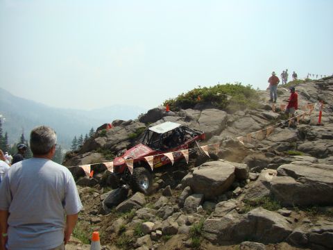 1989 Ford Bronco - A custom off-road vehicle tackles a challenging rocky terrain during an event.