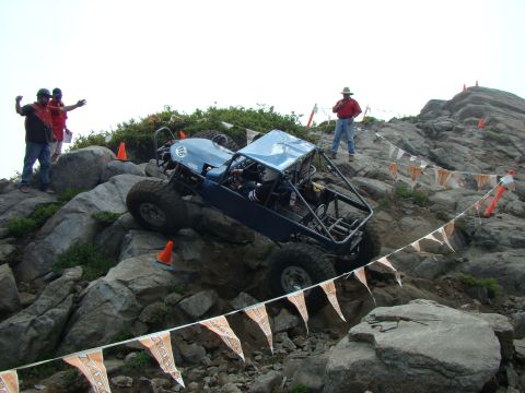 1989 Ford Bronco - A custom off-road vehicle tackles a challenging rocky terrain during an event.
