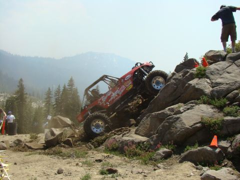 1989 Ford Bronco - A custom-built off-road buggy navigates a challenging rocky incline during an event.