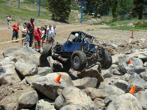1989 Ford Bronco - Custom buggy tackles a challenging rock crawl course with spectators observing.