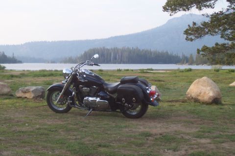 1994 Ford F-150 - A black motorcycle is parked on a grassy area with a lake and mountains in the background.