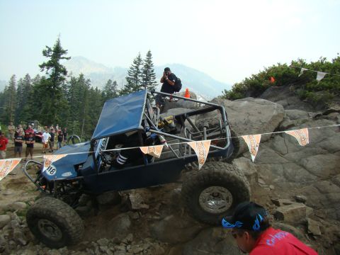 1989 Ford Bronco - A custom-built off-road buggy navigates a challenging rocky terrain during an event.