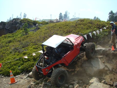 1989 Ford Bronco - A modified off-road vehicle navigates a rocky incline during an event.