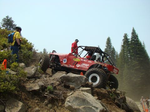 1989 Ford Bronco - Custom off-road buggy navigates a challenging rocky terrain during an event.