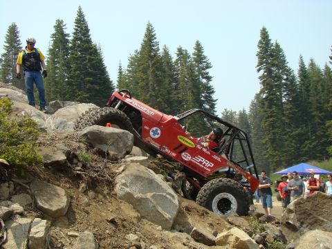 1989 Ford Bronco - A heavily modified off-road vehicle navigates a challenging rocky terrain during an event.