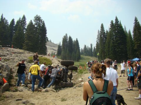 1989 Ford Bronco - A group of people gather around an overturned off-road vehicle during an event.