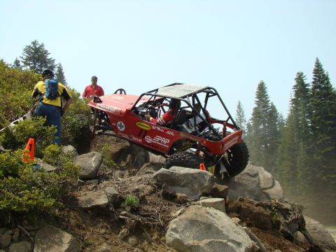 1989 Ford Bronco - Custom off-road buggy tackling a challenging rocky terrain during an event.