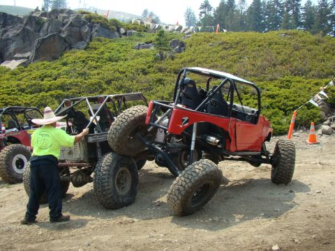 1989 Ford Bronco - Custom off-road vehicles navigate a challenging dirt course with spectators and spectators.