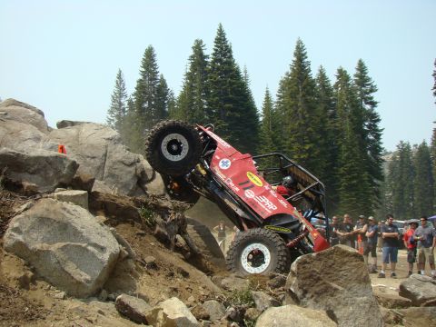 1989 Ford Bronco - Off-road buggy navigates a challenging rocky terrain with spectators observing the action.