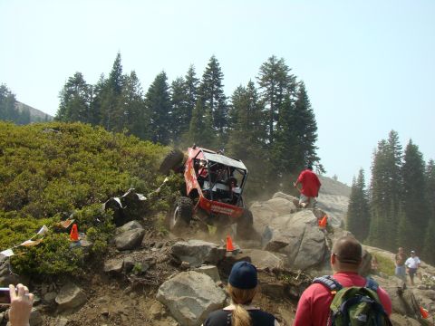 1989 Ford Bronco - An off-road buggy tackles a challenging rocky terrain during an event, with onlookers observing the climb.