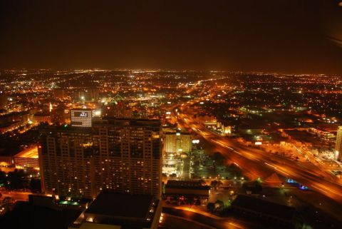 1996 Ford Bronco - A wide view of a city at night, illuminated by countless lights from buildings and roadways.