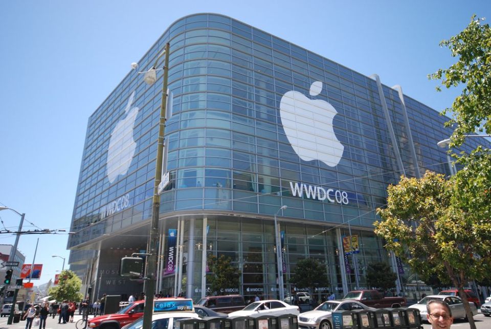 Building with large Apple logos and WWDC08 text, street with cars and people