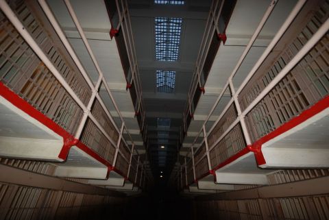 1996 Ford Bronco - Looking down a long prison cell block hallway with barred cells on both sides and skylights above.