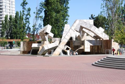 1996 Ford Bronco - An abstract sculpture fountain is active on a sunny day in a plaza with people relaxing.