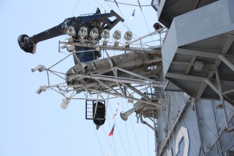 1996 Ford Bronco - Close-up view of a ship's superstructure, lights and flags against a bright sky.
