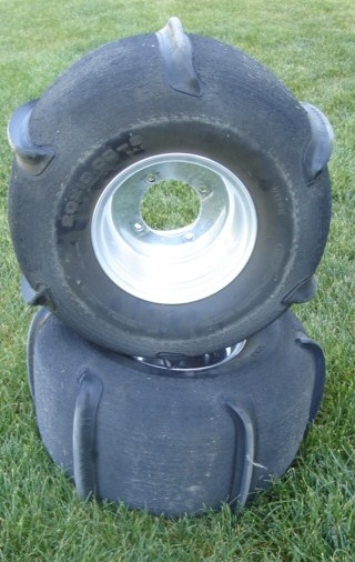 1981 Ford Bronco - A pair of paddle tires are shown resting on a grassy surface.