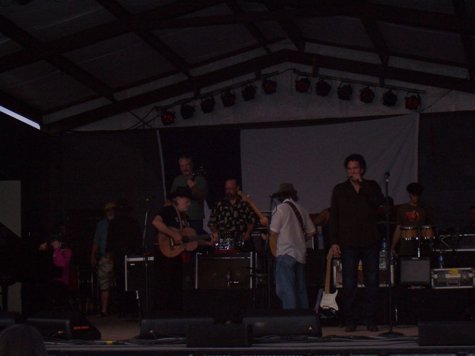 Band playing music on an outdoor stage at night