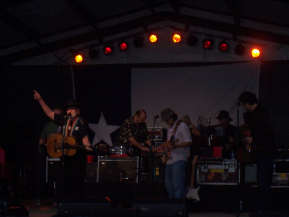 Band performing on stage with a Texas flag backdrop