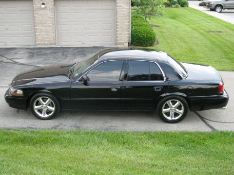 2003 Mercury Marauder - Side view of a black 2003 Mercury Marauder parked in front of a garage.
