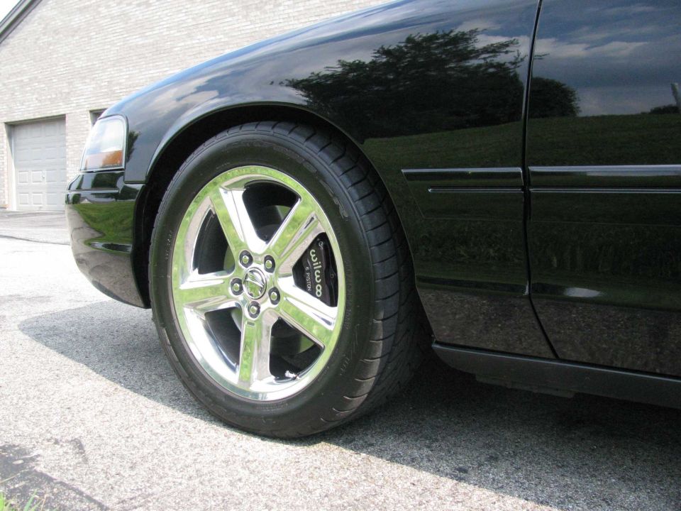 Black sedan front passenger side wheel and brake caliper