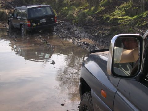 1996 Ford Explorer - Off-roading adventure: two SUVs tackle a challenging muddy path.