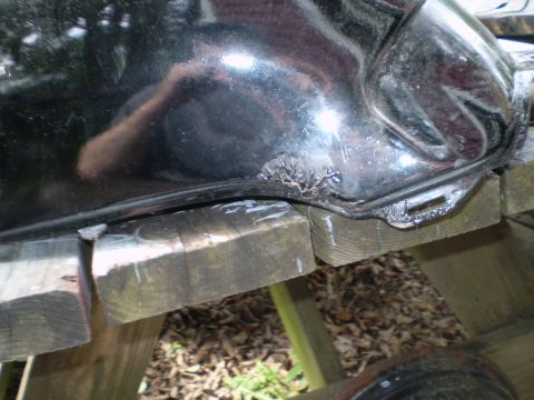 1984 Honda VF700S - Close-up of a damaged motorcycle fuel tank, showing rust and wear.