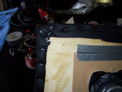 1978 Ford Bronco - This image shows a close-up of a project involving stapling fabric to wood, with various tools and supplies visible in the background.
