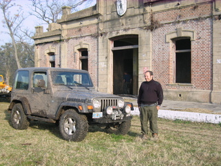 1996 Ford Explorer - A man stands next to a dirty Jeep Wrangler, with another yellow vehicle visible in the background.