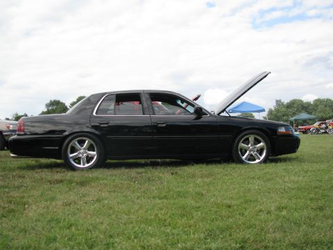 2003 Mercury Marauder - A black 2003 Mercury Marauder is parked on grass with its hood open, showing a side profile.