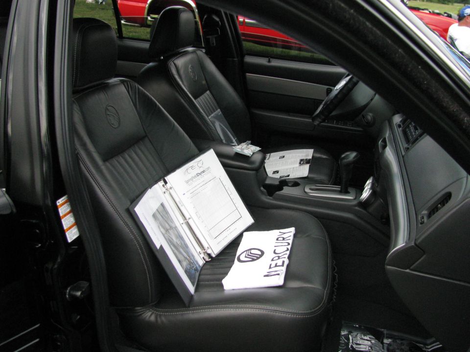 2003 Mercury Marauder interior showing leather seats, center console, steering wheel, and documents on the passenger seat