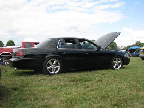 2003 Mercury Marauder - A black 2003 Mercury Marauder is parked on a grassy field with its hood open, under a cloudy sky.