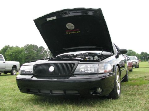 2003 Mercury Marauder - A black 2003 Mercury Marauder is displayed with its hood open, revealing the "Marauder Supercharged" emblem under the hood.