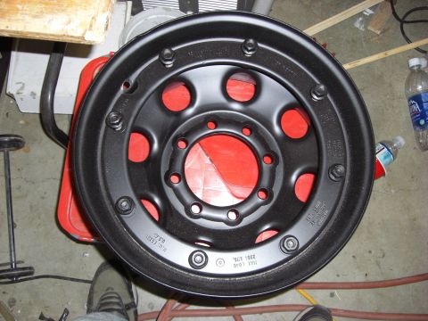 1993 Ford Bronco - A black steel wheel with markings indicating it was manufactured in 1992.